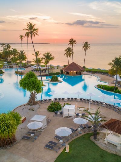 A sprawling lagoon-style pool next to the beach at sunset at the Hyatt Regency Grand Reserve Puerto Rico