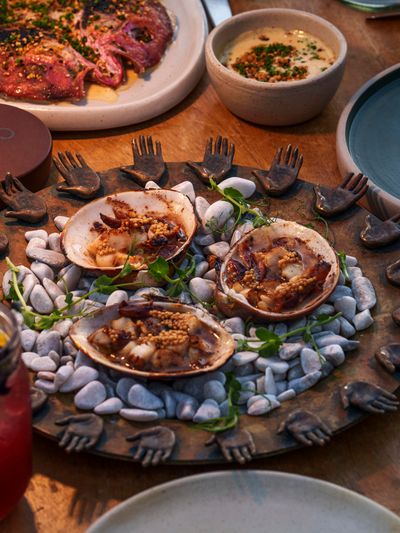 An overhead shot of a table filled with glasses and dishes of food with a circular dish in the middle.