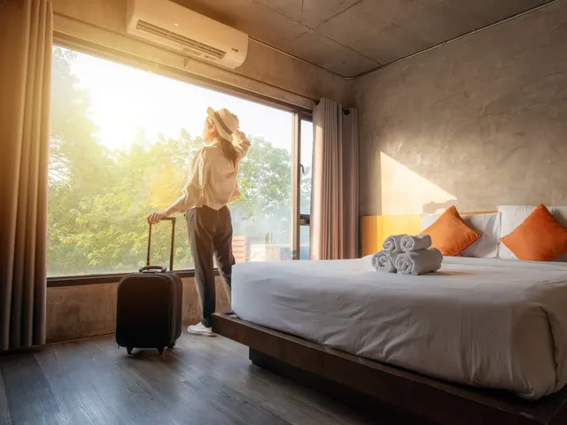 Tourist woman with her luggage in hotel bedroom.
