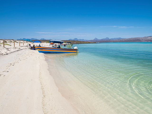 A small boat pulled up to the shore of a white-sand beach in Loreto, Mexico.
