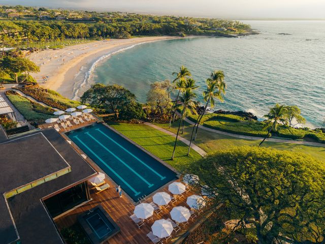 An overhead aerial view of the infinity pool and nearby beach at Mauna Kea Resort in Hawaii.