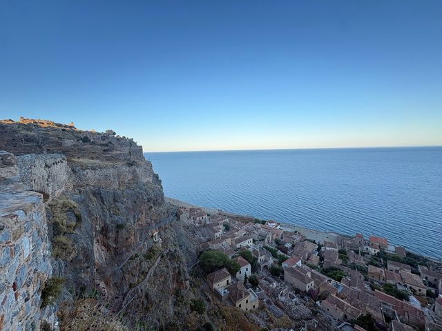 A view over the roofs of houses in Monemvasia, Greece, and the ocean.
