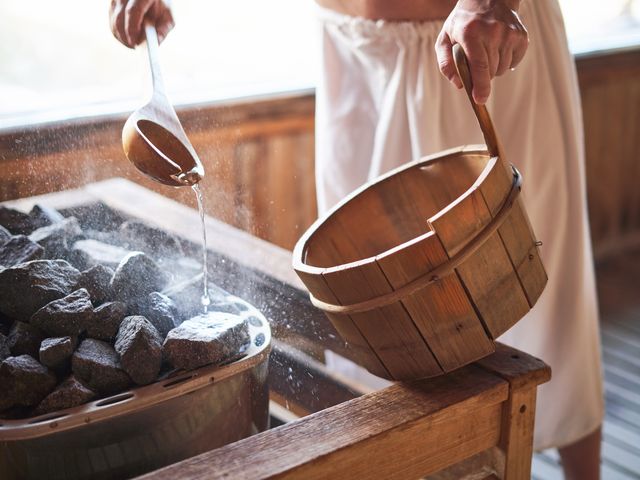 pouring water on hot rocks in sauna