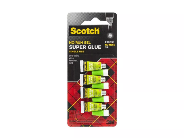 A closed package of four bottles of Super Glue on a white background.