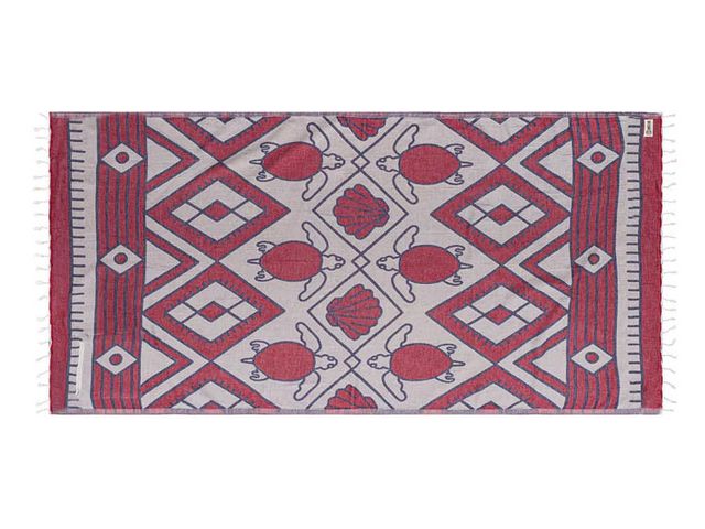 A Sandcloud towel with a red and white turtle design.