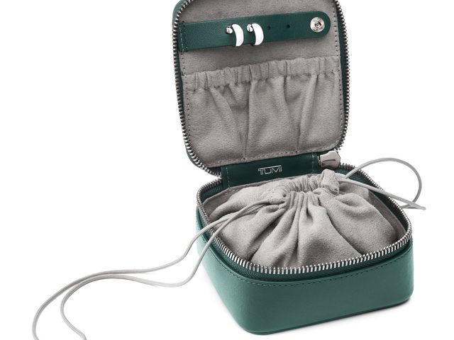 square-shaped green jewelry case opened up to reveal a drawstring closure and multiple pouches lined in microfiber.
