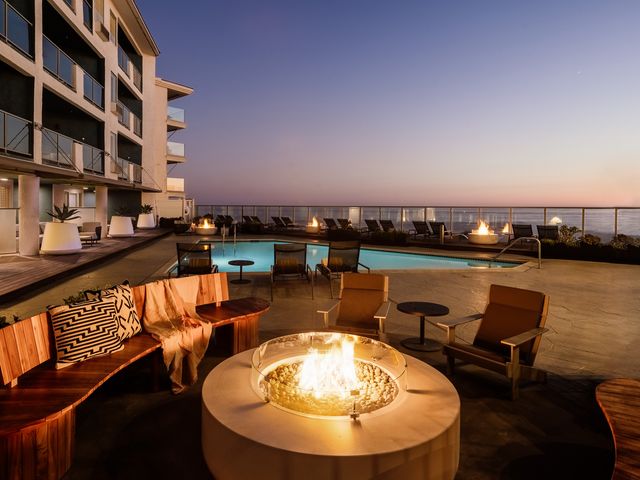 A fire pit at sunset next to a small pool facing the ocean at Beach Terrace Inn in Carlsbad, CA.