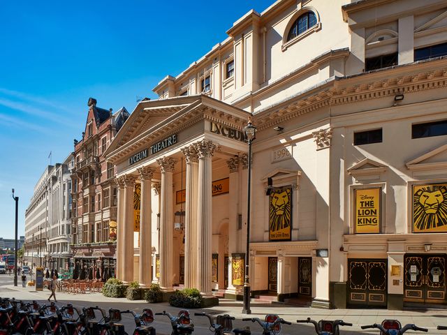 The exterior of the Lyceum Theatre with white columns and Lion King posters.