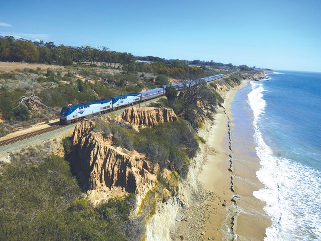 An Amtrak Coast Starlight train seen running alongside the ocean.
