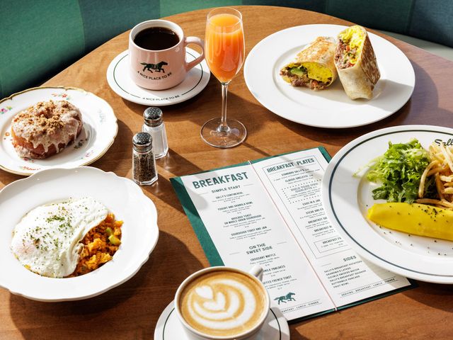 A green-striped booth with a table covered in breakfast dishes and a menu at Sally's Stay Awhile in Nashville.