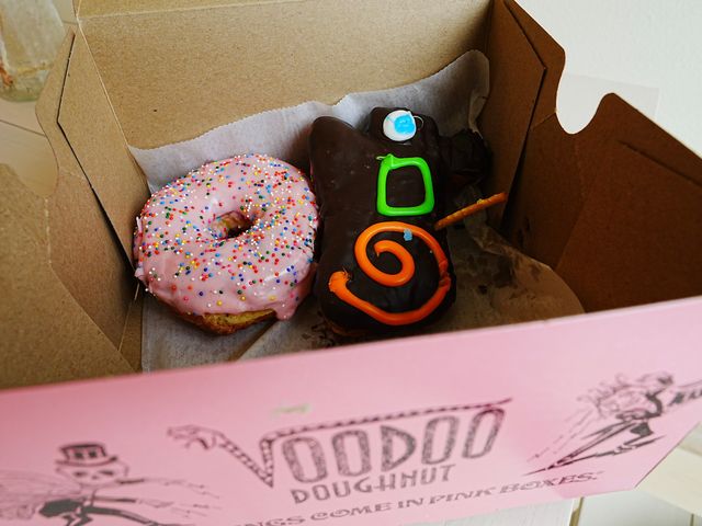 Assorted donuts from Voodoo Doughnut in Portland, Oregon in a pink box.