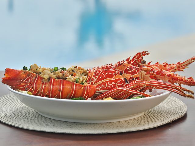 A prepared lobster dish on a white plate.