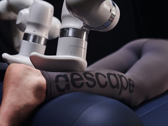A closeup view of legs being massaged by an Aescape robot while on the table.
