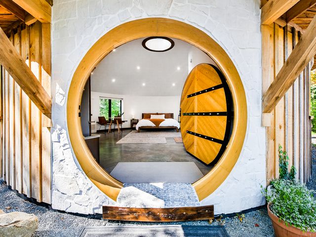 A yurt at Finger Lakes Cider House with the circular door open showing a room with a bed.