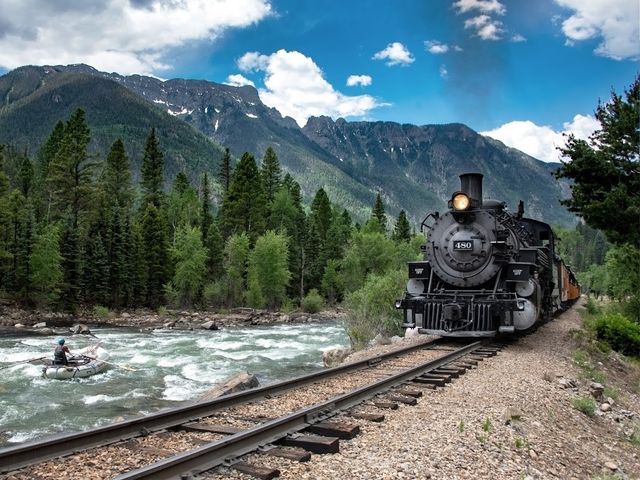 Durango & Silverton Narrow Gauge Railroad along a river and mountains in Colorado.