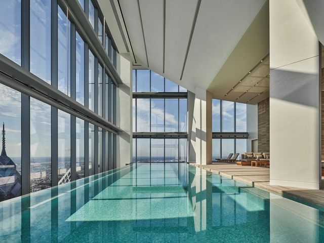 An indoor pool surrounded by windows at the Four Seasons Hotel Philadelphia at Comcast Center.