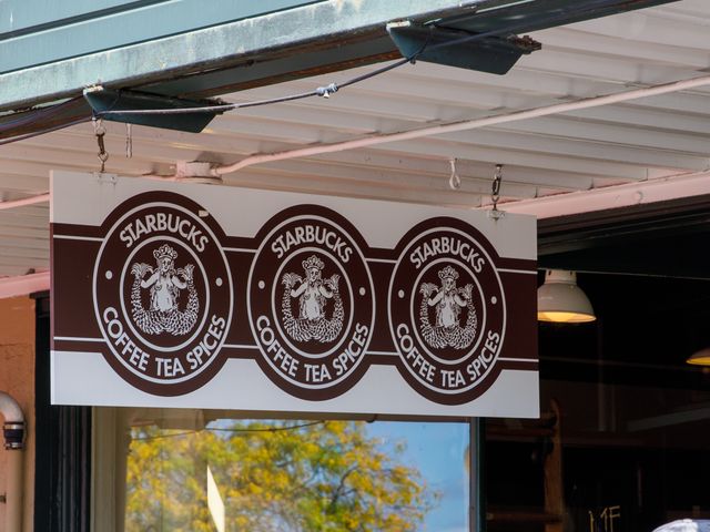 A sign for the original Starbucks with three brown circular logos.