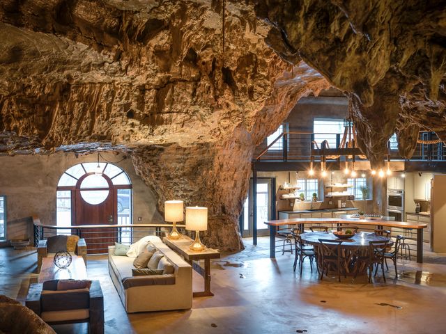 Inside a cave room at Beckham Creek Cave Lodge with a living room and kitchen under real rock walls.