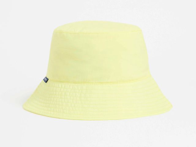 A light yellow Solbari bucket hat against a white background. 