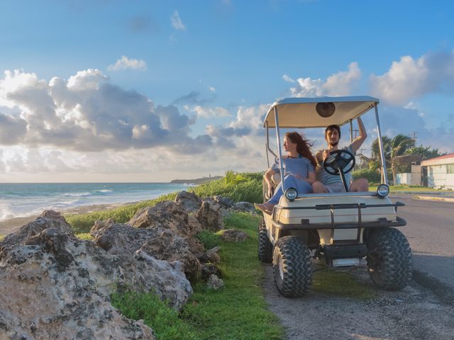 A couple sitting in a golf cart parked by the beach on Isla Mujeres.