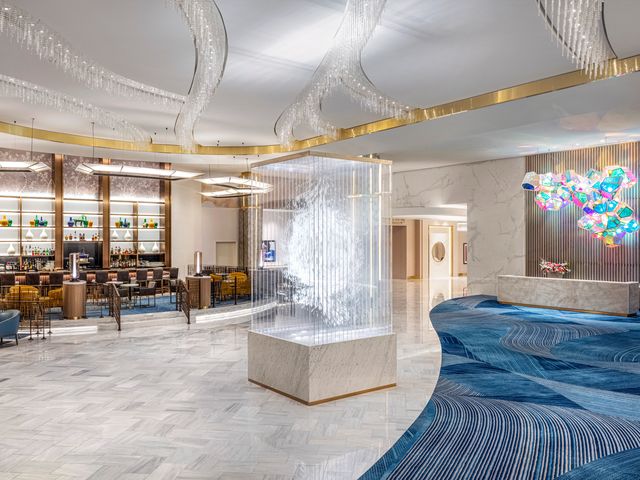 The lobby at the Conrad Las Vegas with its check-in desk and colorful contemporary art.