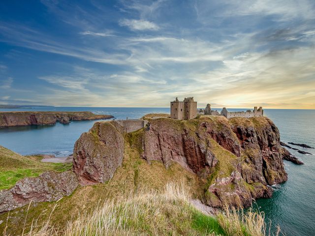 The ruins of Dunnottar Castle, a medieval castle, perched on a rocky cliff on a headland on the northeast coast of Scotland in Stonehaven.