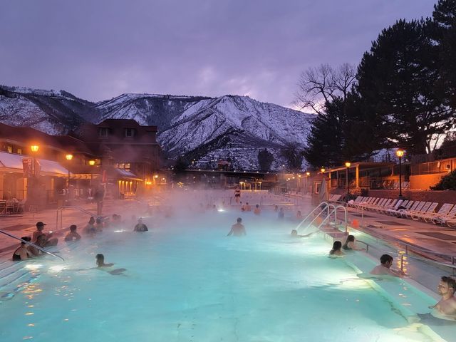 The pool at Glenwood Hot Springs Resort at night with lights on and a fog sitting over the water.