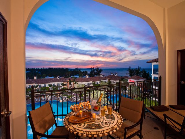 A table set for two on a patio overlooking a resort pool at Beaches Turks and Caicos.