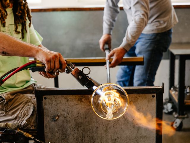 Two people blowing glass at Barrio Glassworks in Carlsbad, California.