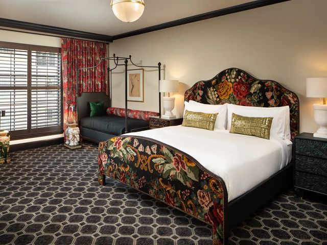 A room at Hotel Zaza Austin with bold patterns on the carpet, drapes, and bed.