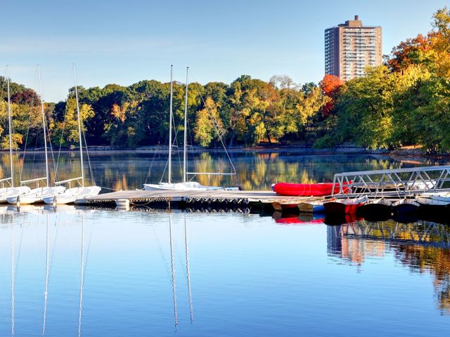 A pond in Jamaica Plain with a small dock with boats.