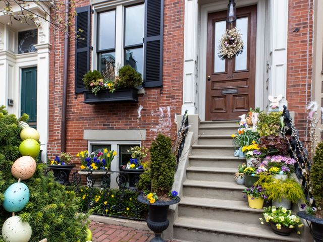 The stoop of a brick building filled with flowers in Boston's South End.