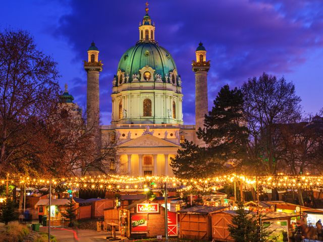 A view of the Christmas Market on Karlsplatz (Charles' Square) and the Karlskirche (St. Charles Church) in the city of Vienna, Austria at night.