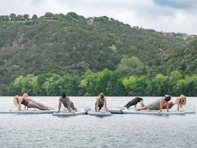 A group performs yoga on paddleboards on the water at Lake Austin Spa Resort.