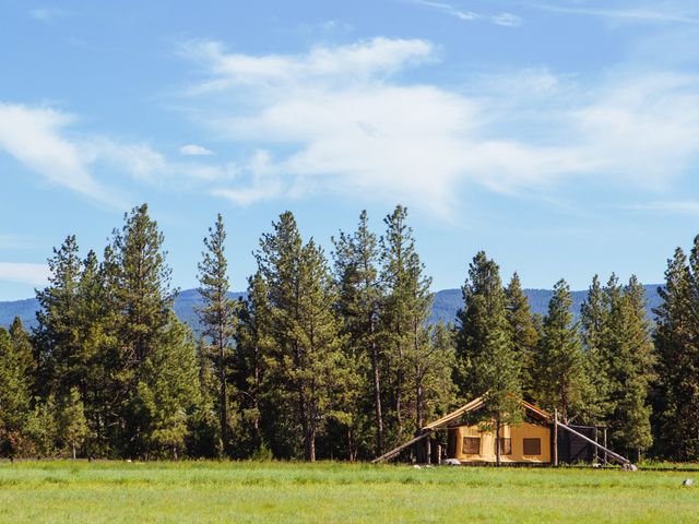 A tent at Paws Up Montana surrounded by trees and wilderness.