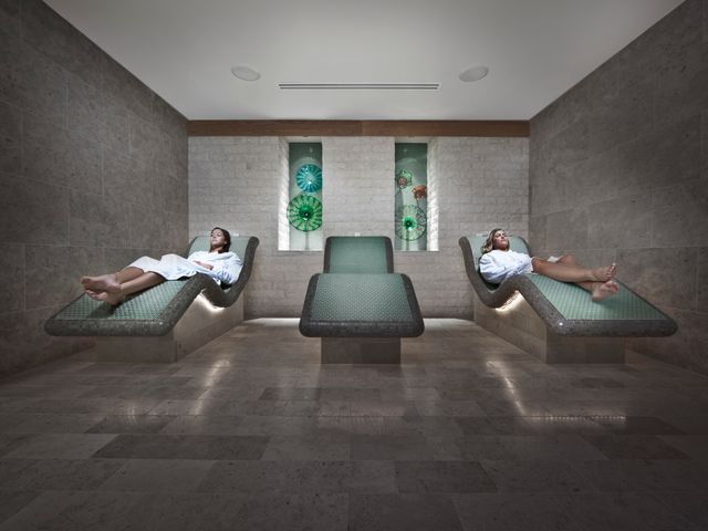 Two women sitting on loungers with the middle one empty at the Waldorf Astoria Park City.