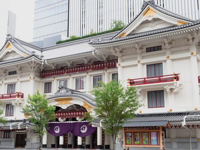 The white exterior of a Japanese building with red accents. 