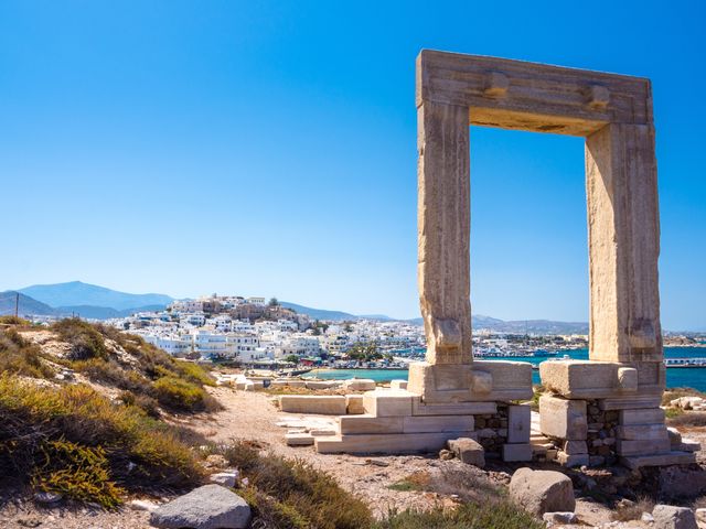 The ruins of the Apollo Temple on Naxos with the city skyline in the distance behind it.