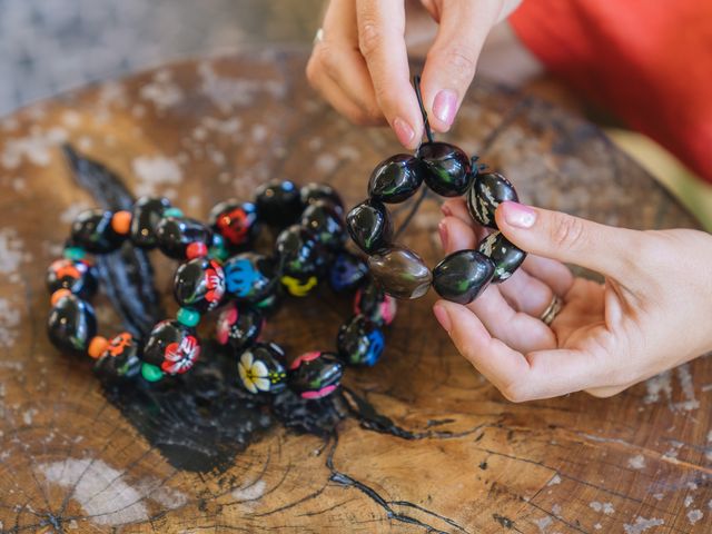 Hands are seen making a nut bracelet at The Royal Hawaiian.