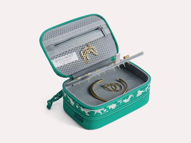 A rectangle-shaped green jewelry case opened up to reveal a mesh pouch, a layer for earrings, and multiple compartments for jewelry.