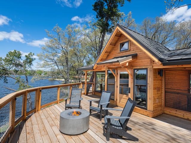 A cabin-style treehouse with a deck overlooking water at Kalahari Resort.