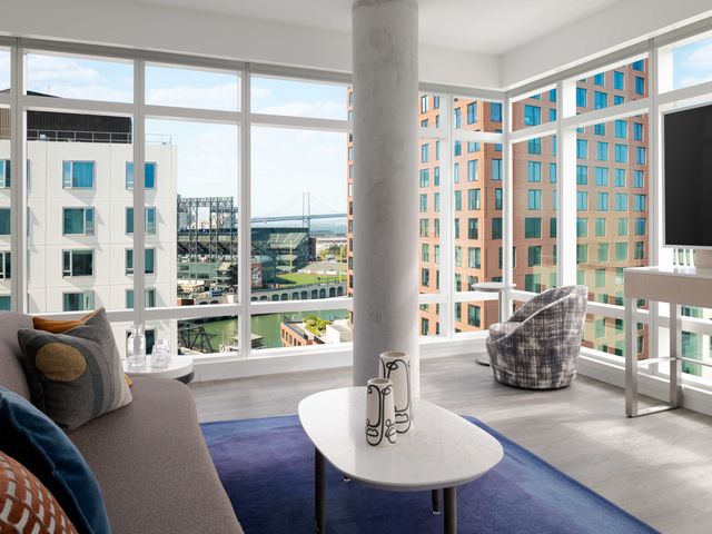 A corner suite with full length windows that have views of Oracle Park in San Francisco.
