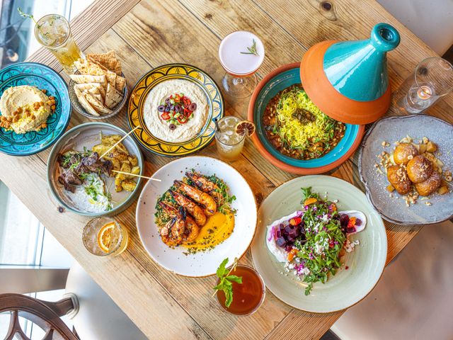 An overhead view of colorful food dishes on a table including a tagine.