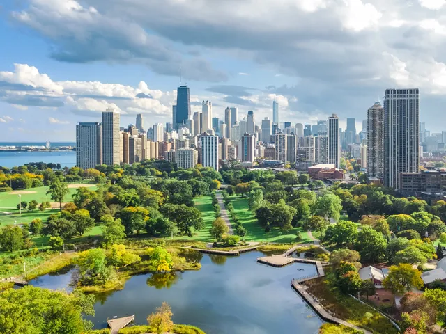 An aerial drone view over Chicago's Lincoln Park with skyscrapers behind it.