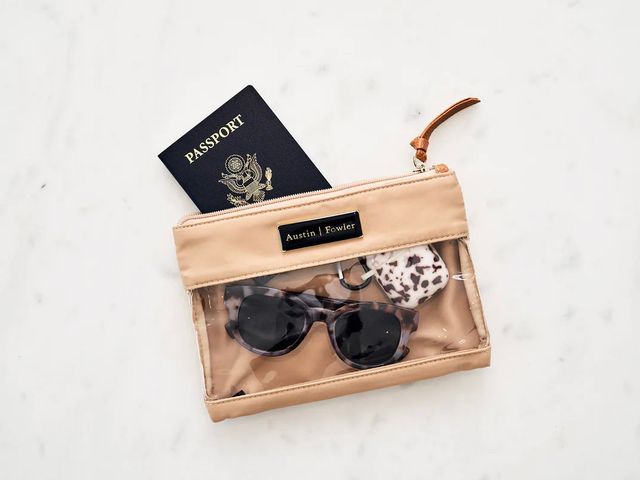 Everyday Packing Tote from Austin Fowler filled with sunglasses, passport, and other accessories.