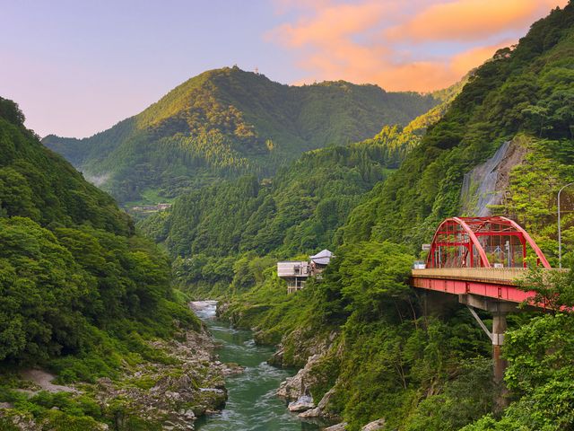 Iyano Valley in Shikoku, Japan with lush greenery and a red bridge.