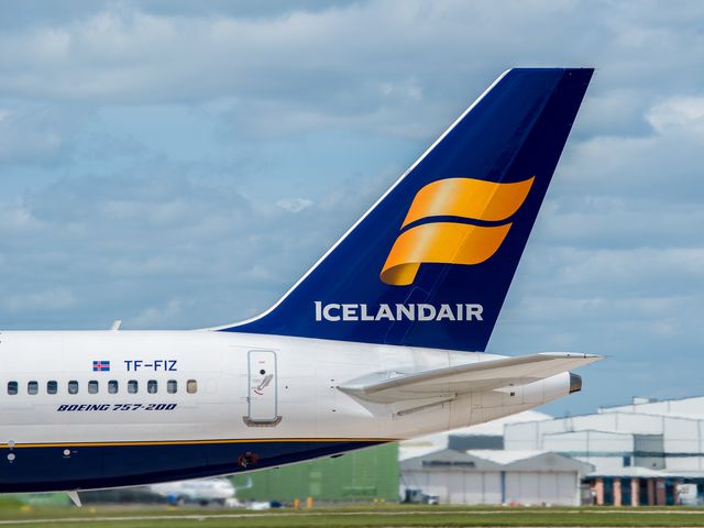 The tail of an Icelandair plane siting on the tarmac.