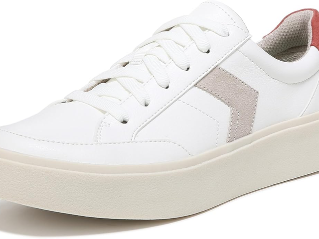 A close-up of white sneakers with a chevron stripe on the side. 