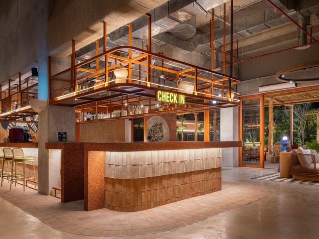A wooden and tiled bar area with a big yellow sign that says check-in.