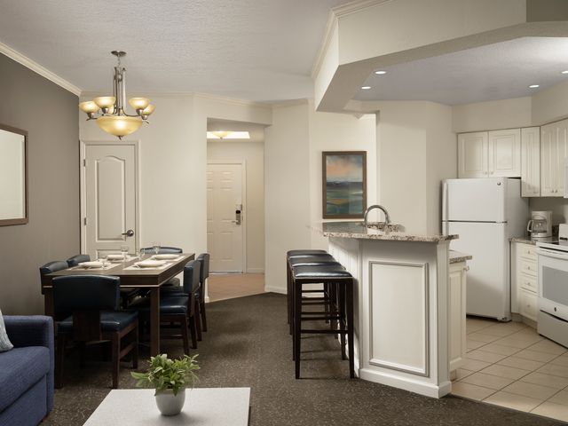 A dining area and kitchen inside a guest room at Caribe Royal Orlando.